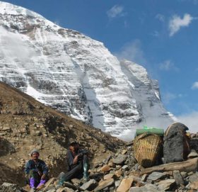 धौलागिरि हिमालको आधार शिविर जाने पर्यटकको सामान बिसाएर हिमालको फेदीमा आराम गर्दै भरिया । तस्बिरः कमल खत्री